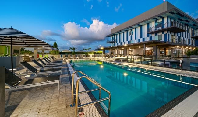 Resort-style swimming pool a pool with a building in the background