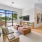 a clubhouse room with a tv, a couch, coffee table and a large window